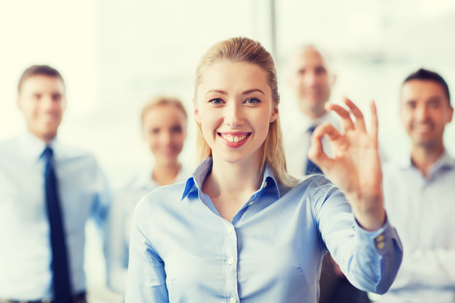 business, people, gesture and teamwork concept - smiling businesswoman showing ok sign with group of businesspeople in office